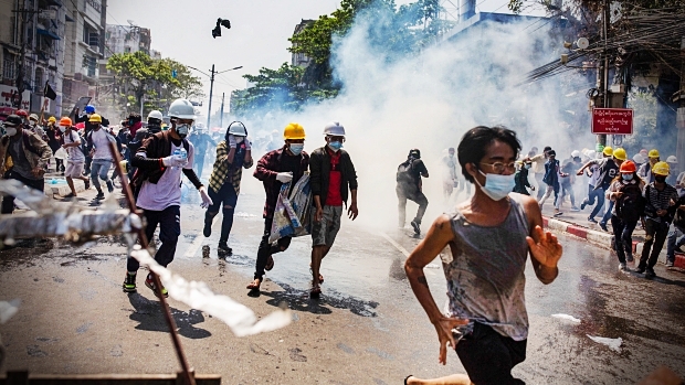 Photo Credit: Pengunjuk rasa anti junta militer di Myanmar lari dari gas air mata yang ditembakkan oleh polisi selama demonstrasi di Yangon pada hari Senin, (01/03/2021). Setidaknya 18 orang tewas selama akhir pekan karena polisi Myanmar dilaporkan menggunakan amunisi peluru tajam langsung terhadap pengunjuk rasa. GETTY IMAGES