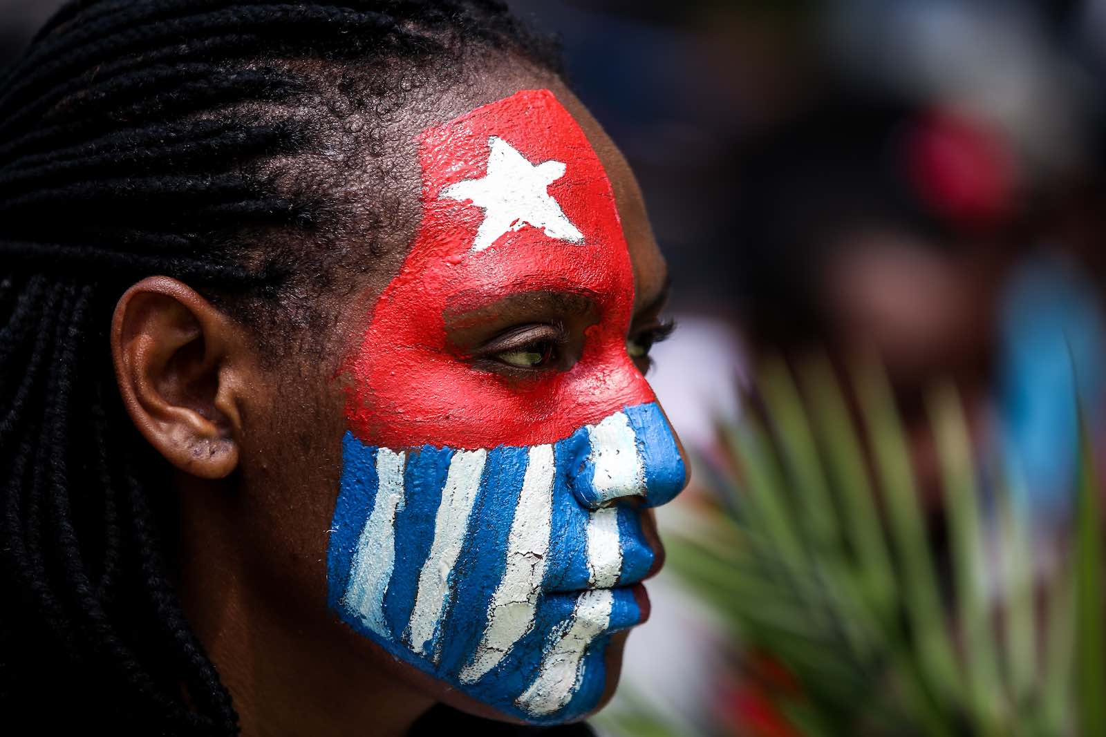 Seorang mahasiswa Papua melukis wajahnya dengan bendera Papua Barat, Bintang Kejora saat unjuk rasa di Jakarta, Indonesia, pada 28 Agustus 2019. Mahasiswa dan aktivis berkumpul untuk protes mendukung seruan Papua Barat untuk kemerdekaan dari Indonesia dan menuntut pelecehan rasial kasus terhadap mahasiswa Papua di Surabaya, Jawa Timur. (Foto oleh Andrew Gal / NurPhoto via Getty Images)