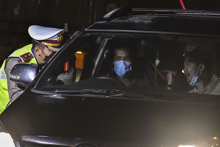Petugas Kepolisian (kiri) memeriksa dokumen pengendara yang melintas di check point penyekatan arus mudik di Tol Cikarang Barat, Kabupaten Bekasi, Jawa Barat, Kamis (6/5/2021) dini hari. Petugas gabungan memberlakukan penyekatan pemudik jelang perayaan Hari Raya Idul Fitri 1442 H guna memutus rantai penyebaran wabah COVID-19.(ANTARA FOTO/FAKHRI HERMANSYAH)