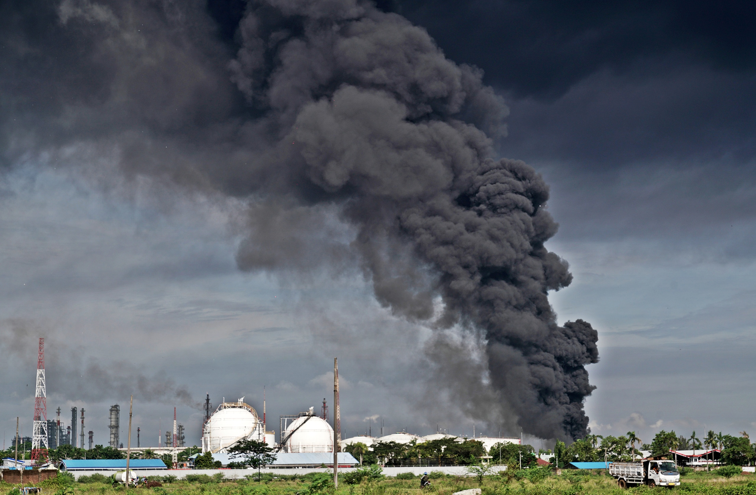 Photo Credit: Asap hitam terlihat mengepul di tanki penyimpanan benzene yang terbakar di Area KIlang Pertamina RU IV Cilacap, Jateng, Sabtu (12/6/2021). Tanki nomor 205 di area 39 Kilang RU IV Pertamina Cilacap, terbakar pada pukul 19.45 wib (11/6/2021), dan hingga saat ini masih terlihat mengepulkan asap hitam. ANTARA/Idhad Zakaria